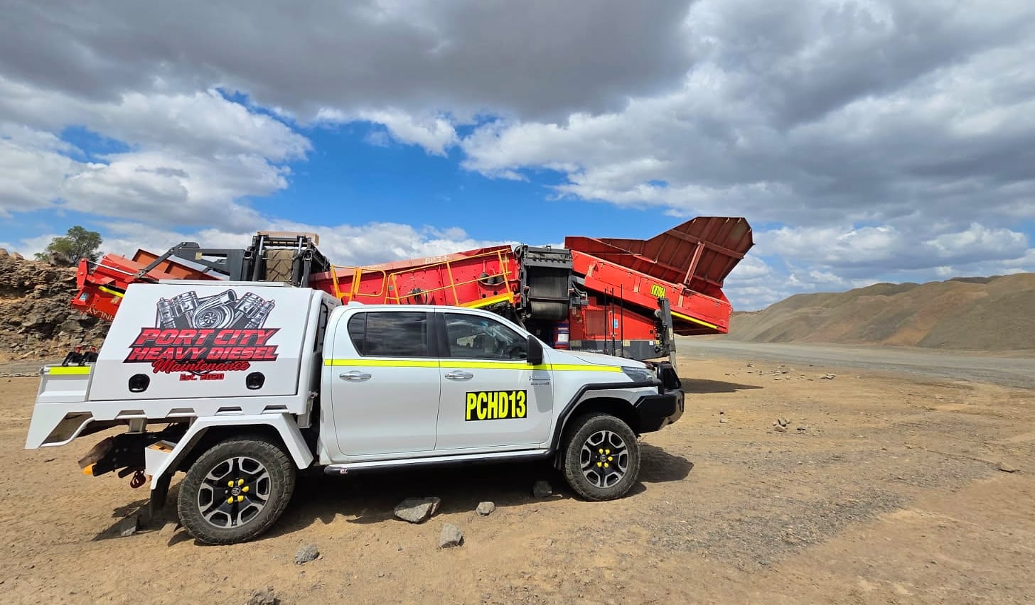 A Port City service ute at a quarry in front of a red mobile screening plant